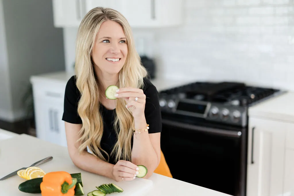 Leila Page, RD — holding fresh produce in her kitchen